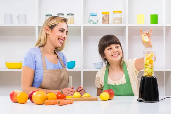 Mor och hennes dotter gör smoothie — Stockfoto