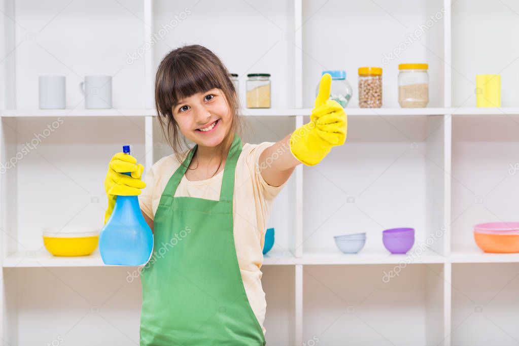 Little girl cleaning and showing thumb up