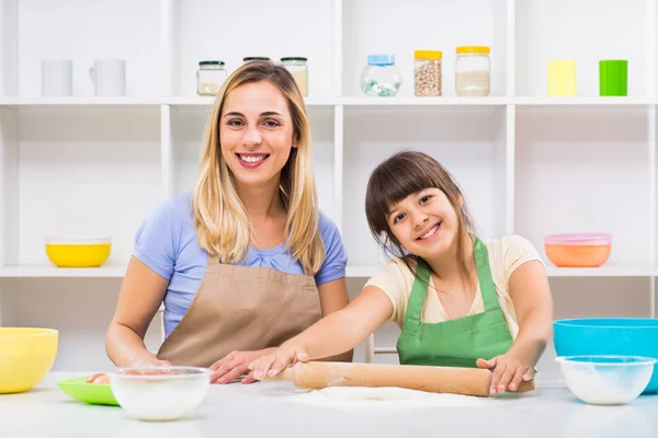 Mutter und Tochter rollen Teig und backen Plätzchen — Stockfoto