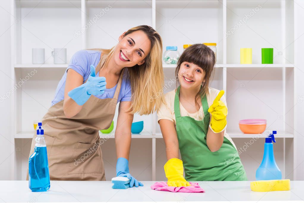 Happy mother and daughter cleaning and showing thumbs up