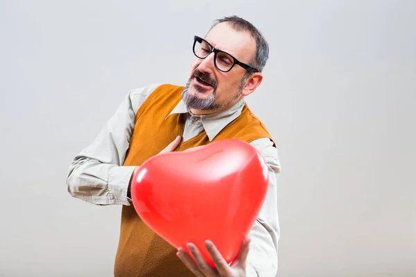 Nerdy man med hjärta form ballong — Stockfoto