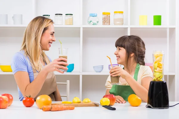 Mother and daughter making and drinking smoothies — Stock Photo, Image