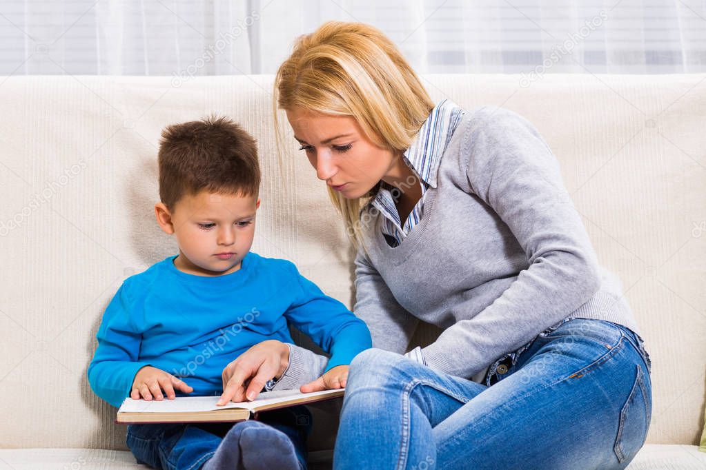 Mother and son reading book together