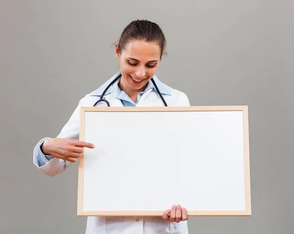 Femme médecin tenant tableau blanc — Photo