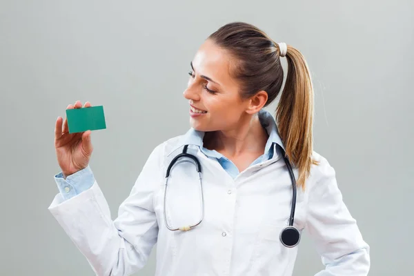 Médico feminino segurando cartão de visita — Fotografia de Stock