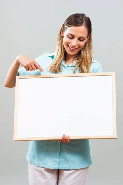 Vacker sjuksköterska pekar på whiteboard — Stockfoto