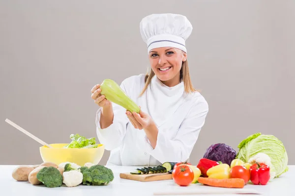 Chef femenino mostrando calabacín mientras hace comida saludable —  Fotos de Stock