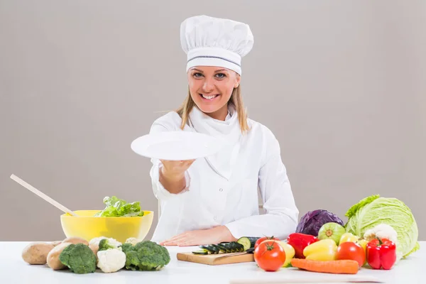 Chef feminino mostrando prato enquanto faz refeição saudável — Fotografia de Stock