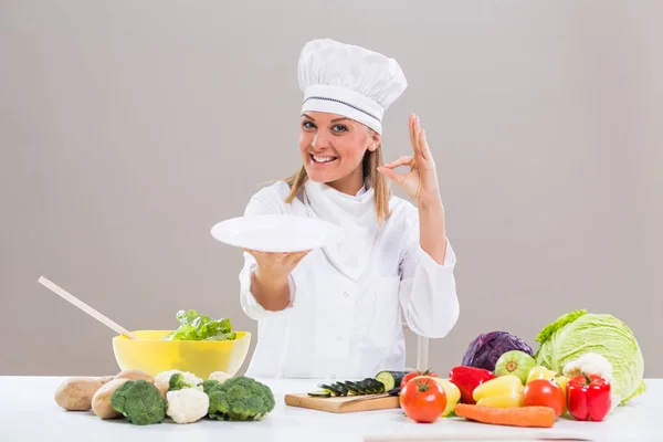 Žena kuchař desku a ok znamení — Stock fotografie