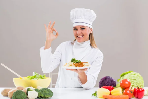 Chef feminino mostrando refeição preparada e sinal ok — Fotografia de Stock