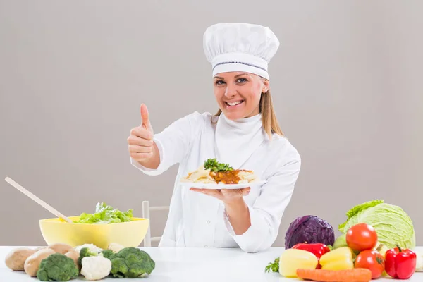 Chef feminino mostrando refeição preparada e polegar para cima — Fotografia de Stock