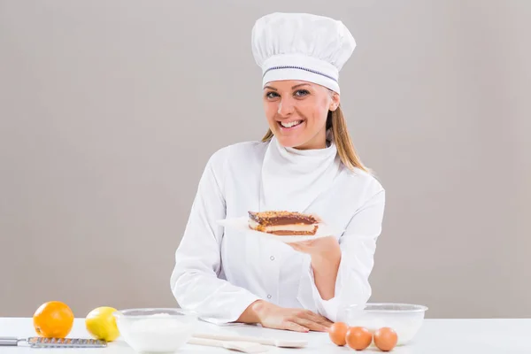 Vrouwelijke banketbakker met deel van koek — Stockfoto