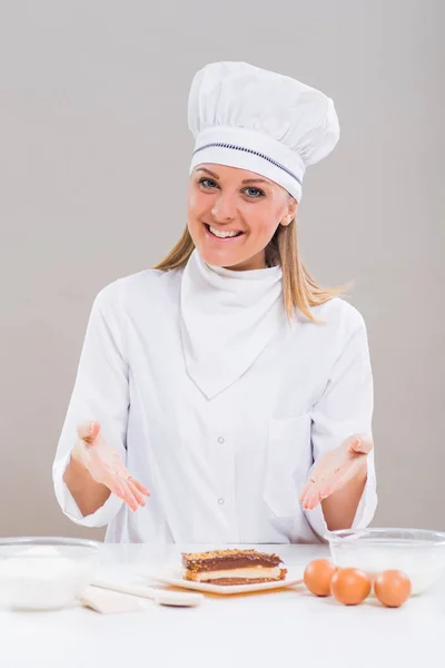 Female confectioner with slice of cake