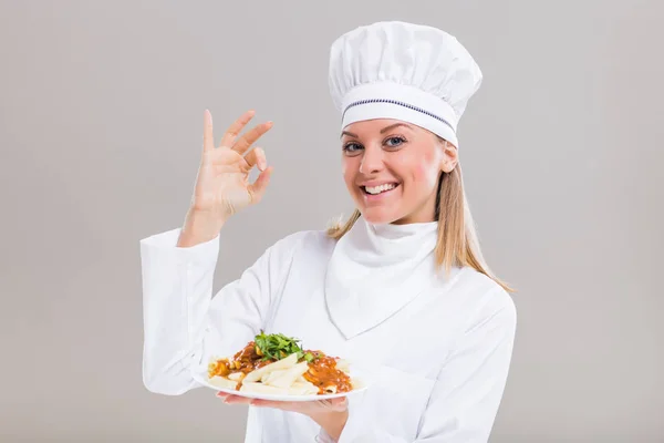 Vrouwelijke chef-kok met bereide maaltijd gebaren — Stockfoto
