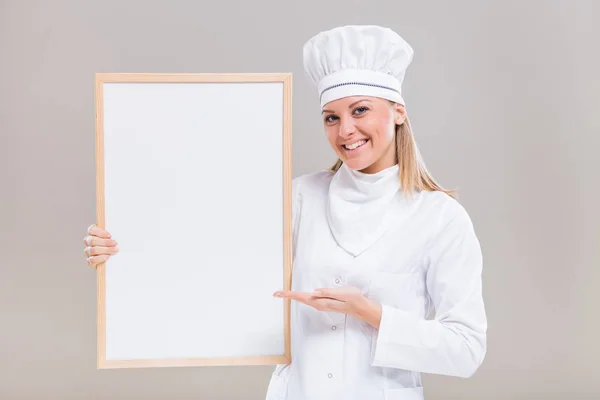 Prachtige vrouwelijke chef-kok weergegeven: whiteboard — Stockfoto