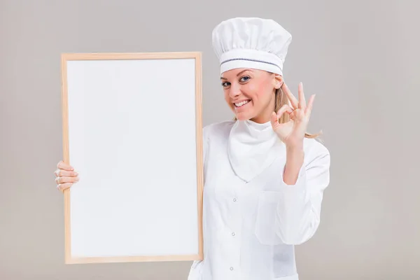 Vrouwelijke chef-kok met whiteboard en ok teken — Stockfoto