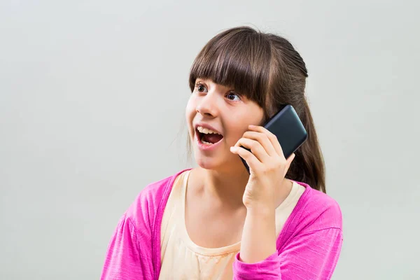 Surprised little girl using mobile phone — Stock Photo, Image