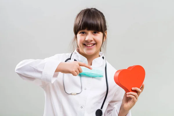 Pequeno médico segurando a forma do coração — Fotografia de Stock