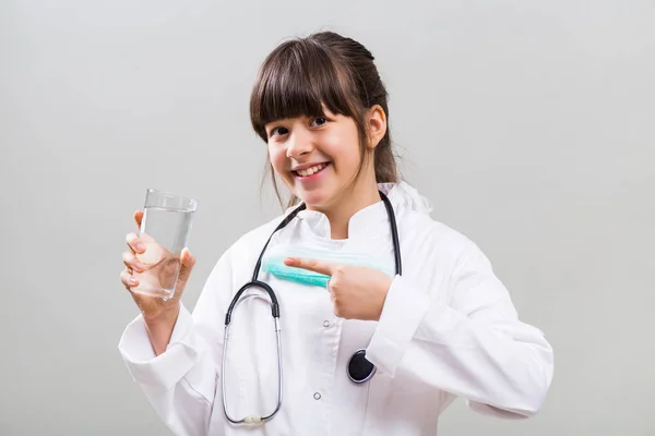 Pequeño doctor mostrando vaso de agua —  Fotos de Stock