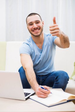 Adam evde çalışma ve başparmak gösterilmesini