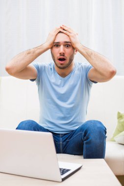 Dizüstü bilgisayar kullanarak panik içinde adam