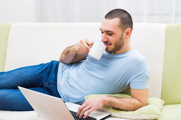 Hombre usando el ordenador portátil y beber café — Foto de Stock