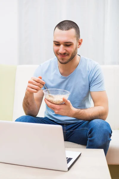 Hombre desayunando y usando laptop — Foto de Stock