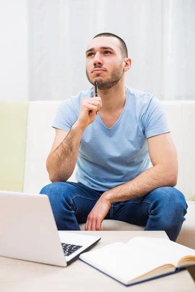Hombre preocupado pensando y usando el ordenador portátil — Foto de Stock