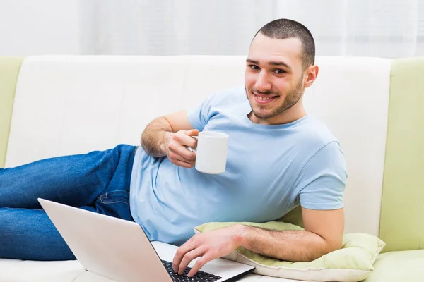 Man met laptop en koffie drinken — Stockfoto