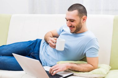 dizüstü bilgisayar kullanarak ve kahve içme adam