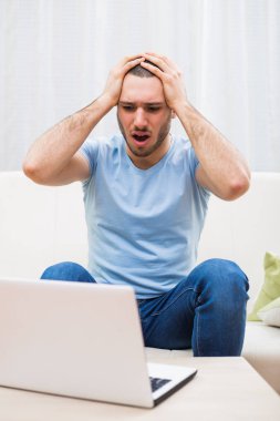 Dizüstü bilgisayar kullanarak panik içinde adam