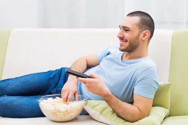 Homme regardant la télévision et mangeant pop-corn — Photo