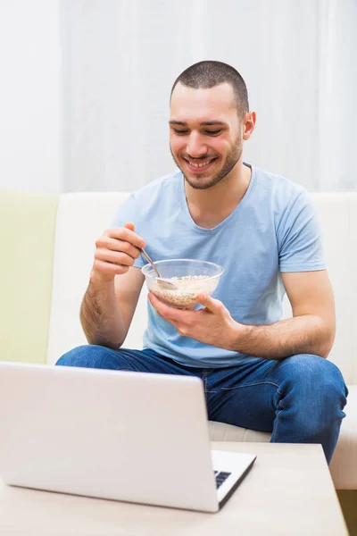 Mann frühstückt und benutzt Laptop — Stockfoto