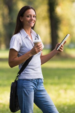 Kahve içme ve dijital tablet kullanarak iş kadını 