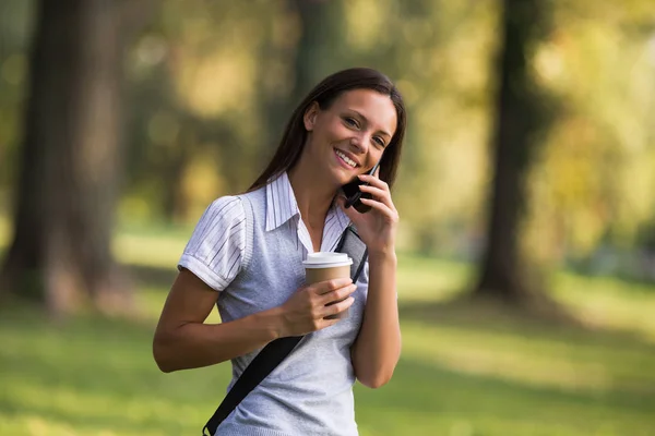 Kobieta pije kawę i rozmawia przez telefon — Zdjęcie stockowe