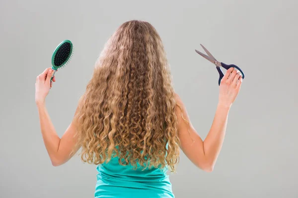 Γυναίκα που κρατά τα μαλλιά βούρτσα και το ψαλίδι. — Φωτογραφία Αρχείου