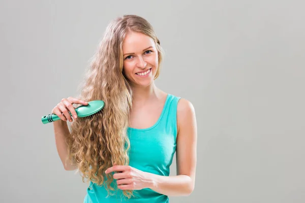 Mujer peinándose el pelo — Foto de Stock