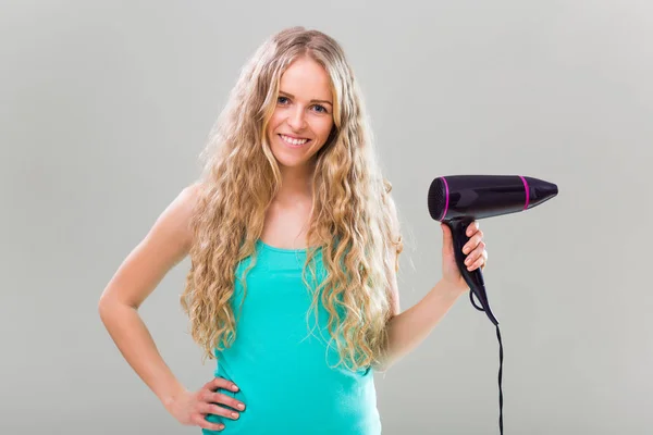 Mulher segurando secador de cabelo — Fotografia de Stock