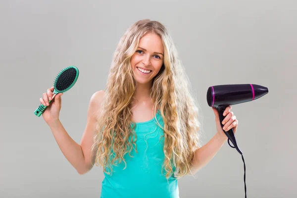 Vrouw met haren borstel en haar droger — Stockfoto