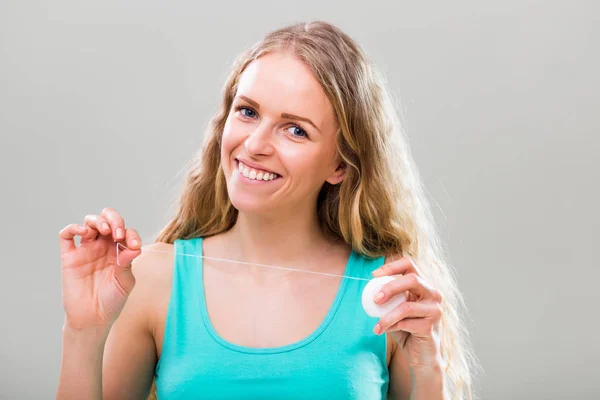 Mujer joven sosteniendo hilo dental — Foto de Stock