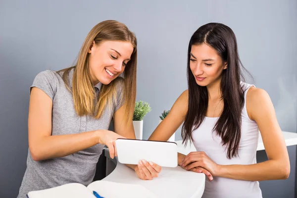 Duas mulheres na recepção do centro de fitness usando tablet digital . — Fotografia de Stock