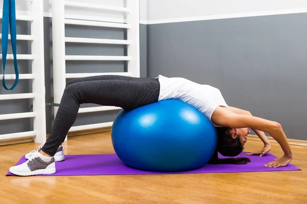 Fitness woman practicing with pilates ball