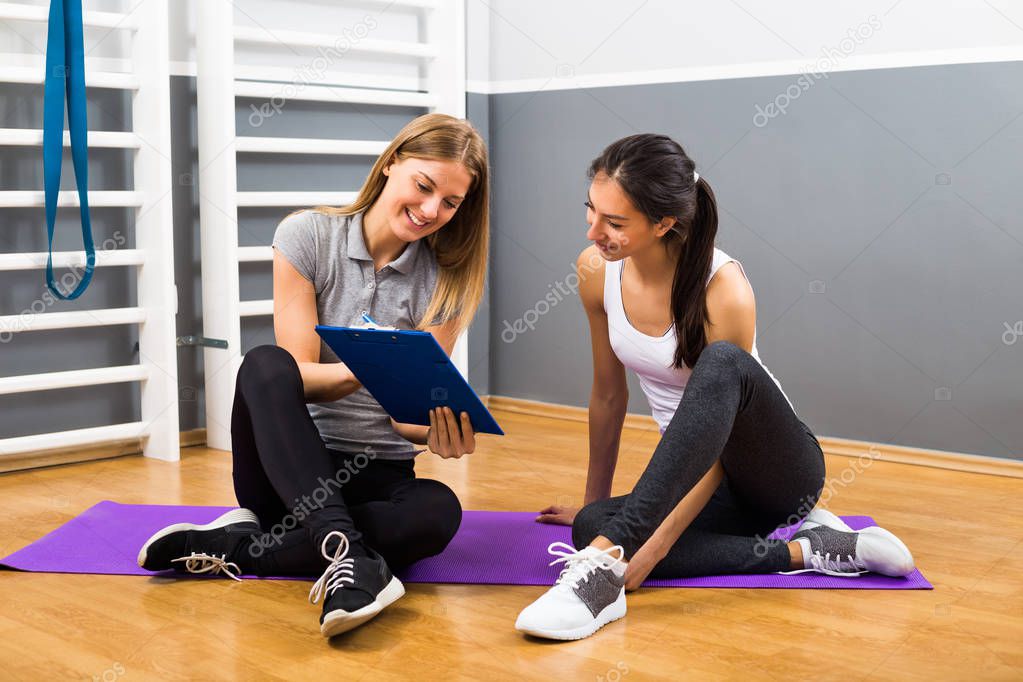 Woman and her personal trainer are having conversation
