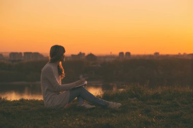 Gün batımında notlar yazma kadın