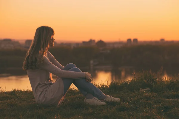 Woman looking sunset over the city — Stock Photo, Image