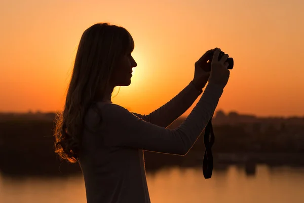 Женщина фотографирует закат — стоковое фото