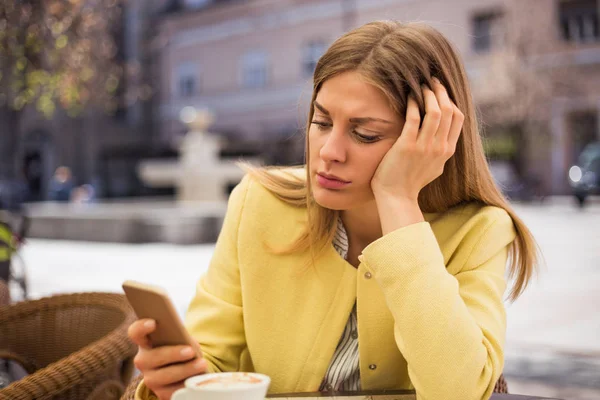 Sad woman looking at phone — Stock Photo, Image