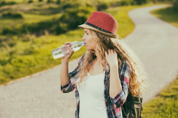 Donna che beve acqua in campagna — Foto Stock