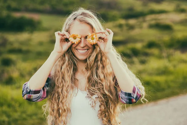 Mulher bonita cobrindo olhos com flores — Fotografia de Stock