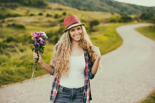 Kvinna med bukett blommor på landet — Stockfoto